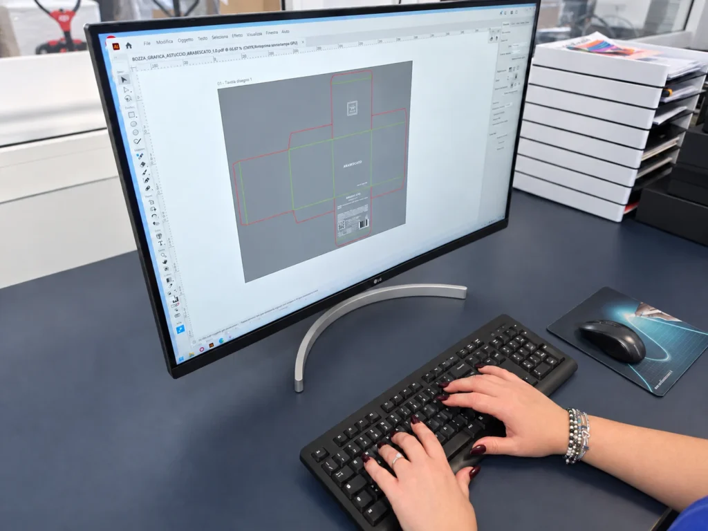 Druckgestaltung einer Faltschachtel auf ihrer technischen Stanzkontur. Das Foto zeigt Adobe Illustrator, das wir ergänzend zu unserem Konstruktionssystem für die grafische Bearbeitung verwenden.