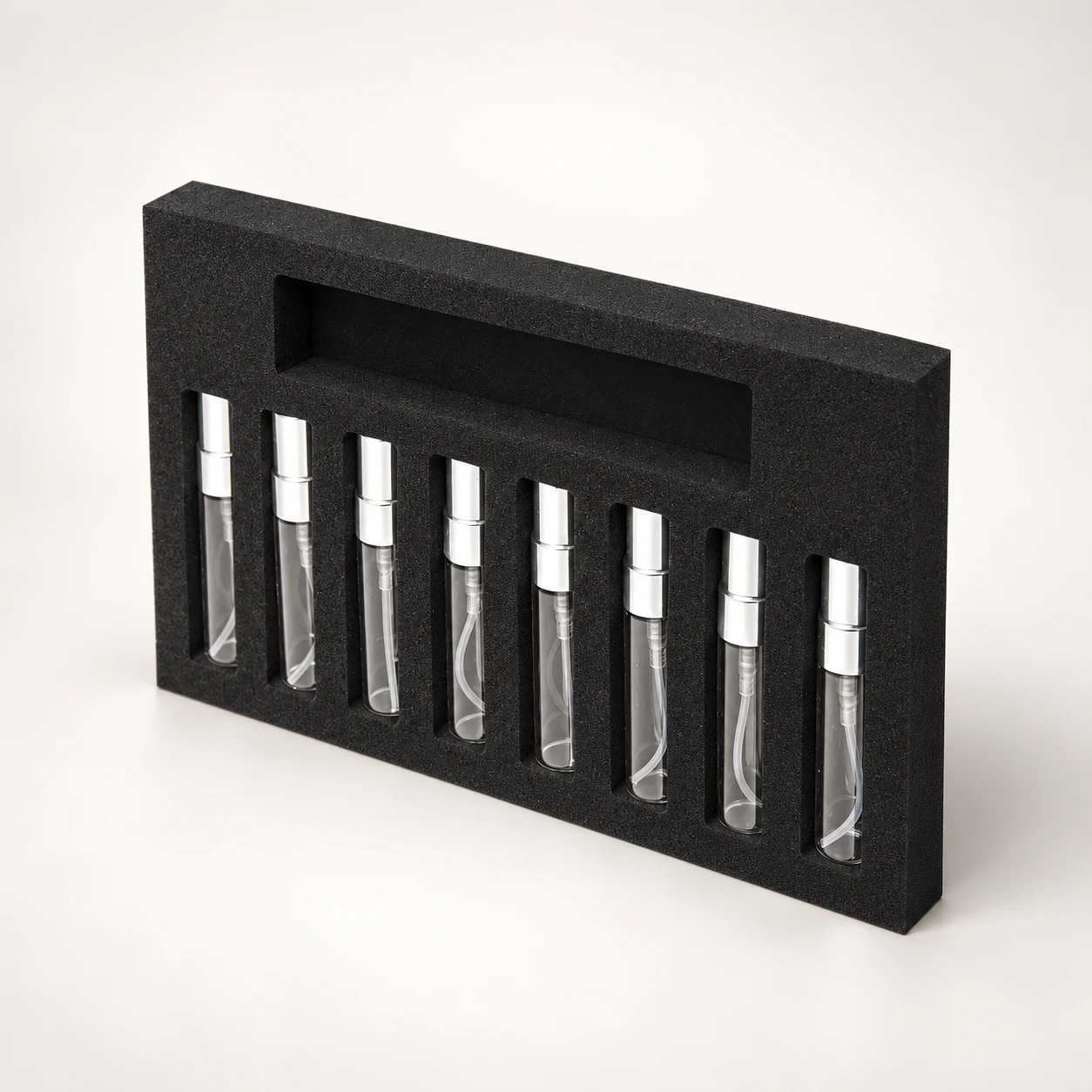 A black shaped insert with eight vials and a separate upper compartment.
