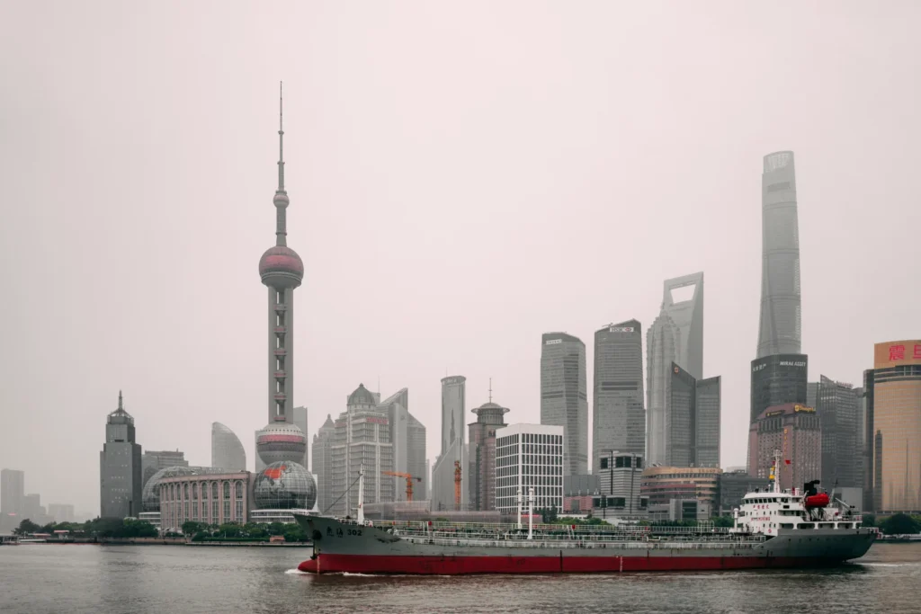 Skyline von Shanghai vom Bund aus gesehen, mit dem Oriental Pearl Tower und einem Schiff auf dem Huangpu. Aufnahme aus dem Jahr 2019.